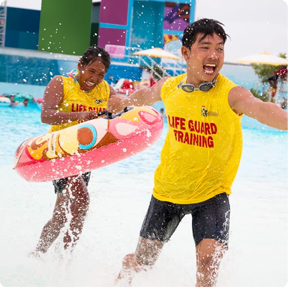 Two ladies are in a locker room getting ready for a day out in the water park. The girl on the right is taking out a towel from one of the lockers.